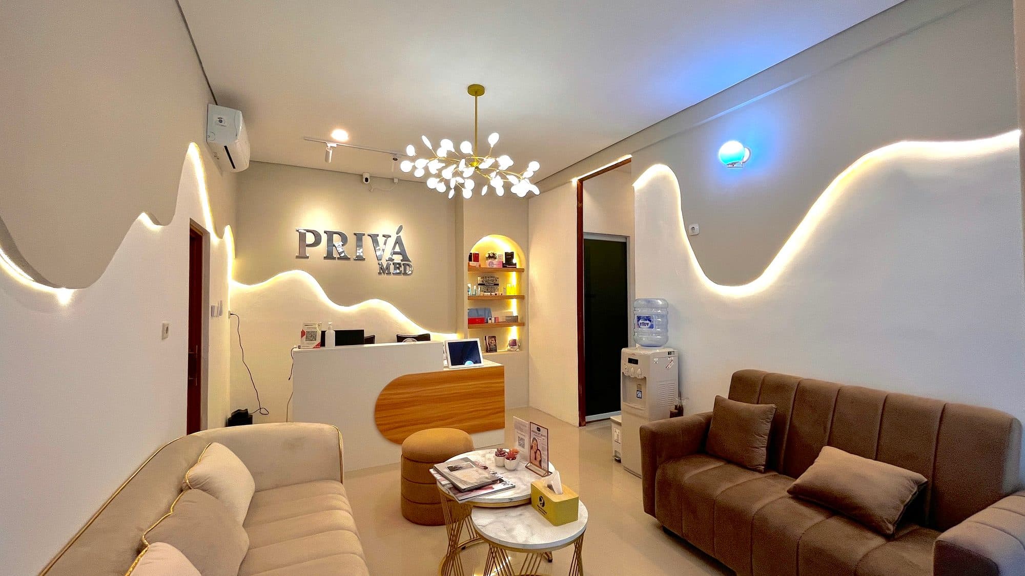 Lobby resepsi PRIVÁ MED dengan meja kayu dan pencahayaan LED
